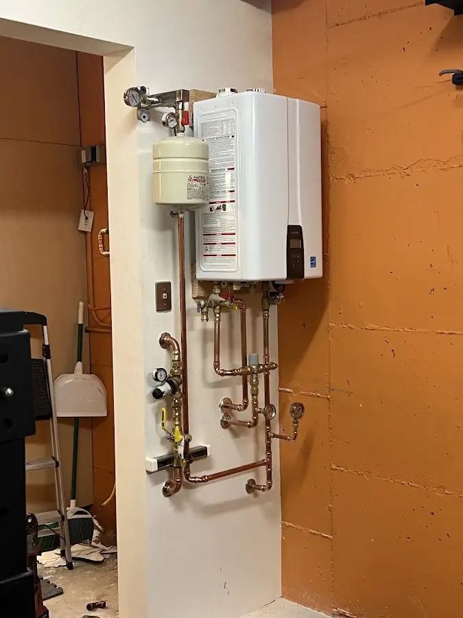 Plumbing technician inspecting water heater connections in Bellefontaine